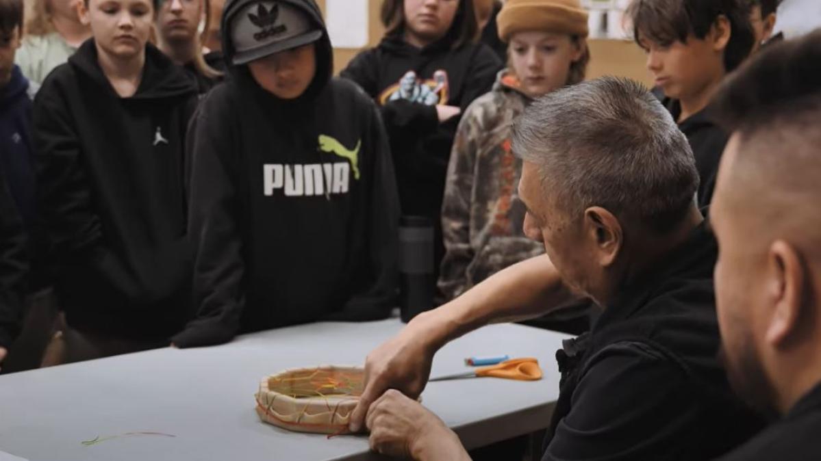 Grade 5 students watching indigenous drum being made