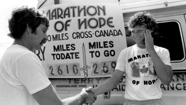 Terry Fox shaking hands in front of Marathon of Hope poster