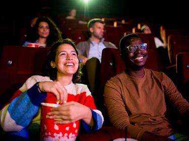 People watching movie in a theatre with popcorn 