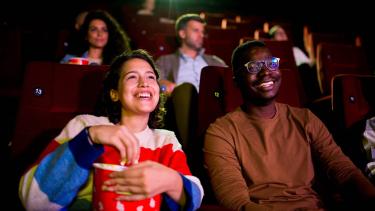 People watching movie in a theatre with popcorn 
