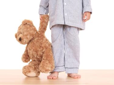 child in PJs with a teddy bear
