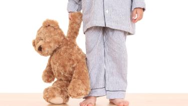 child in PJs with a teddy bear