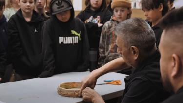 Grade 5 students watching indigenous drum being made