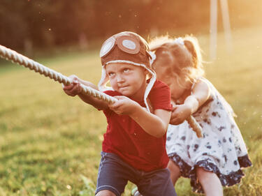 two young children playing tug-of-war