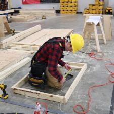 Male student measuring for in carpentry competition